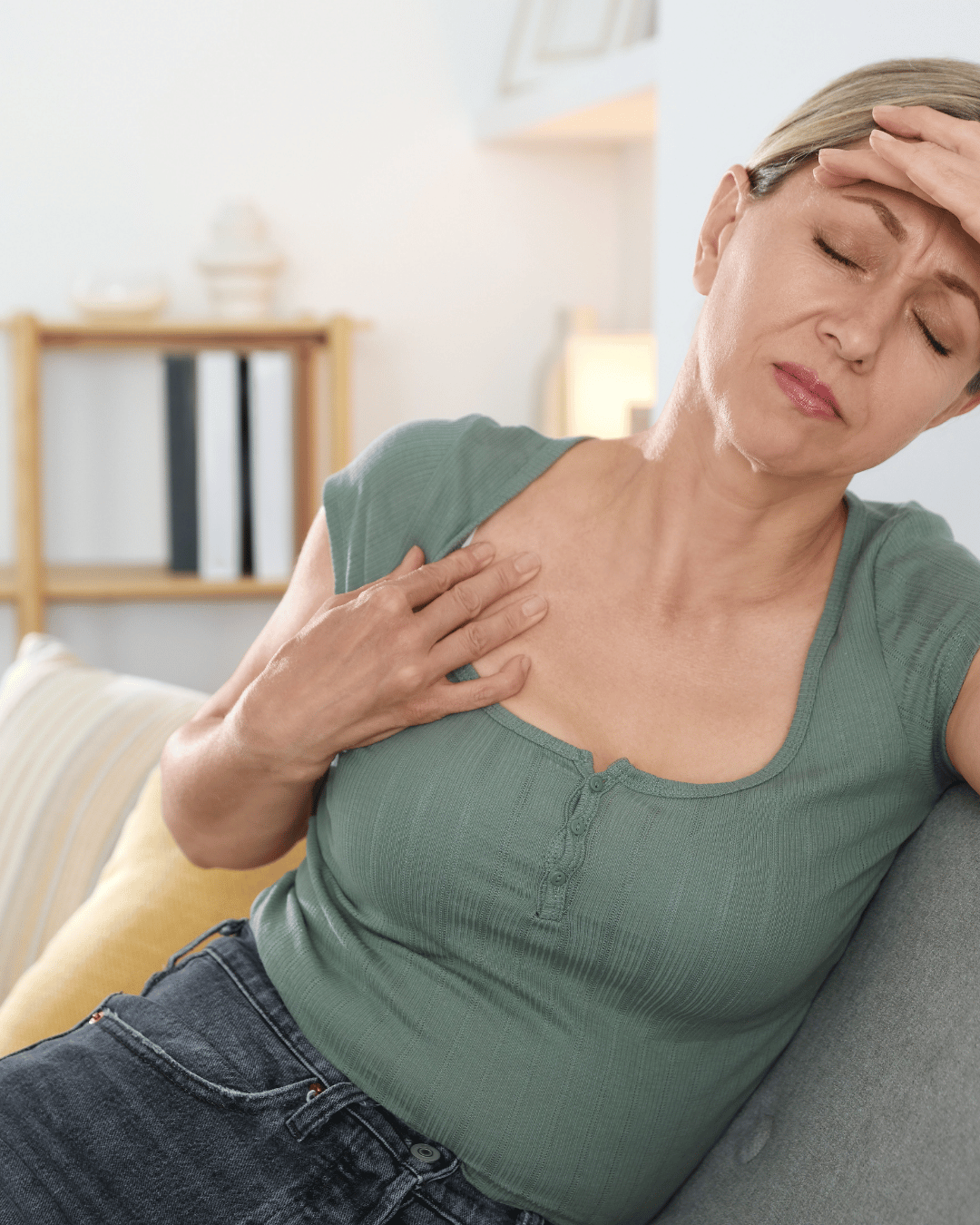 Woman having a hot flash and holding above swollen breast
